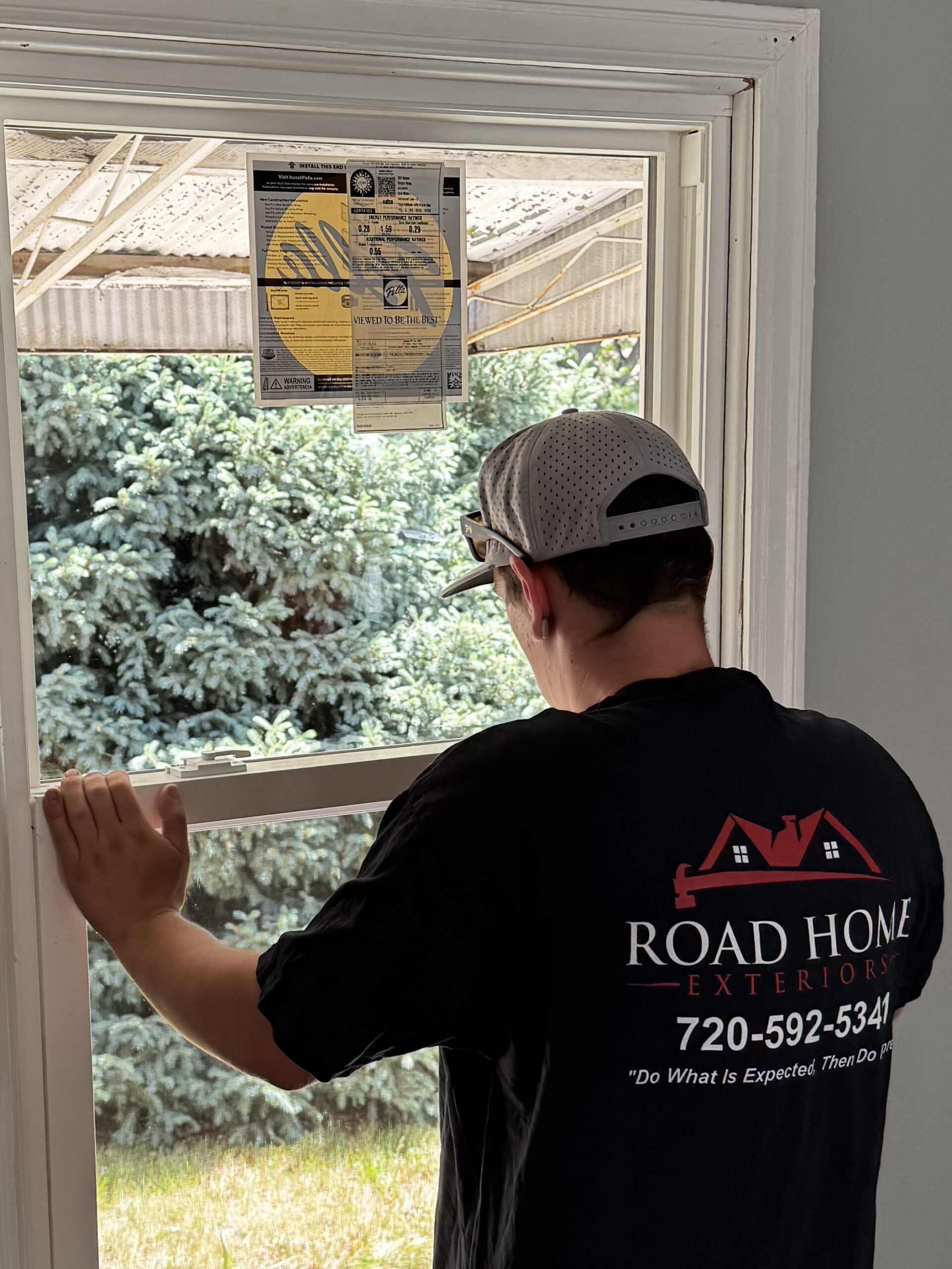 Road Home Exteriors installer fitting a Pella window in an Arvada home