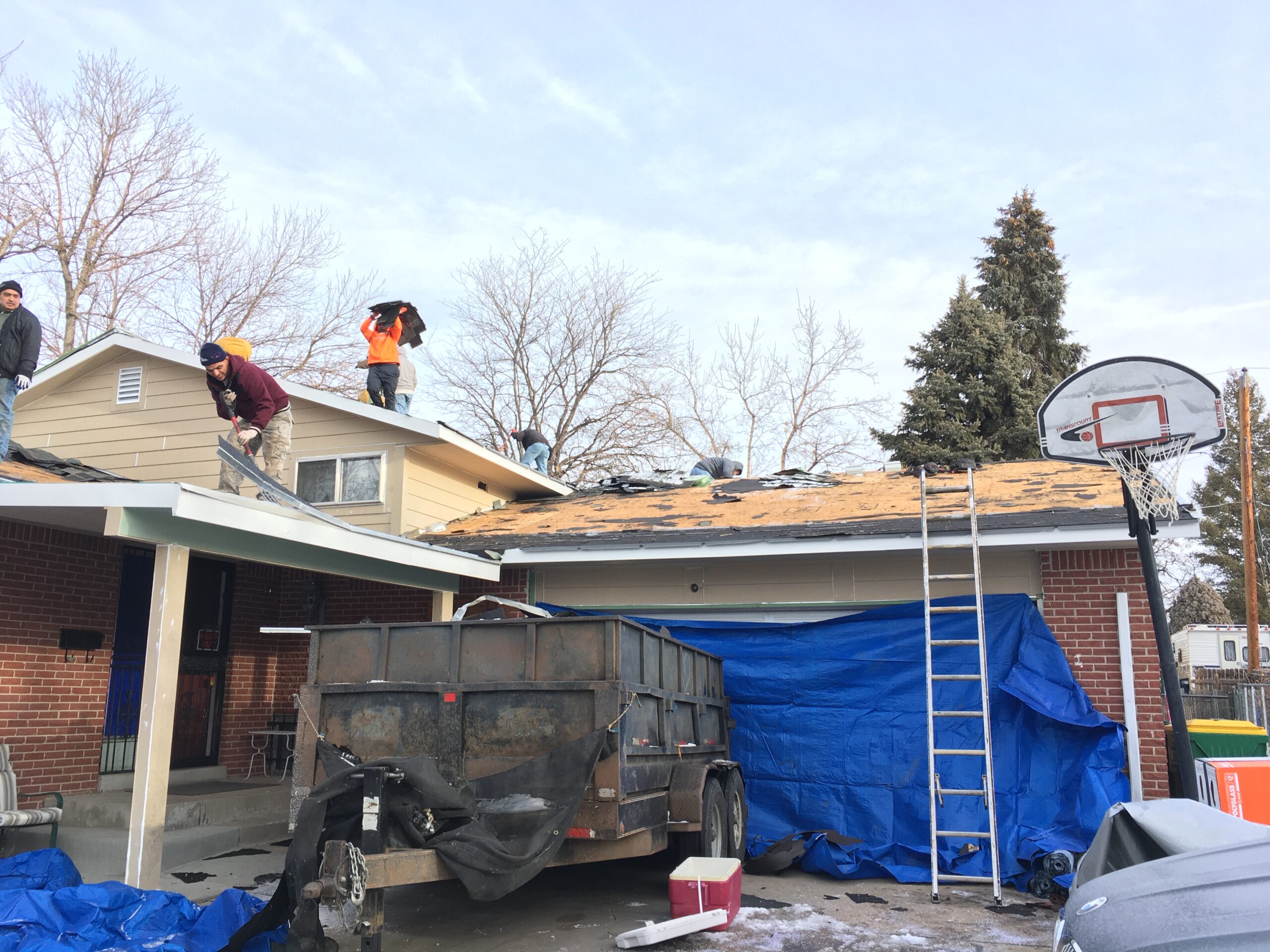 Crew installing Owens Corning shingles on a roof in Arvada